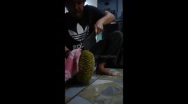 This man sliced open a thorny fruit with a butcher's cleaver