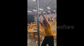 Catapulted into the air!  Viral video shows workers clinging on to roof canopy as it's blown away in strong winds