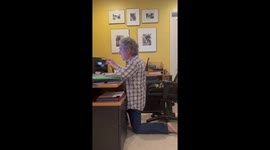 Pampered cat occupies desk chair forcing pet owner to kneel while working