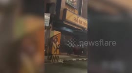 Rampaging buffalo knocks down motorcycle as it charges through street in northern Thailand