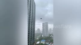 Shirt carried away by storm flies past apartment windows in Thailand