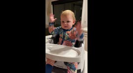 Silly baby has mastered the art of making dinner time with family a giggle gala