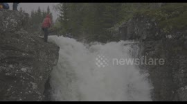 Kayaker does a flip off a waterfall