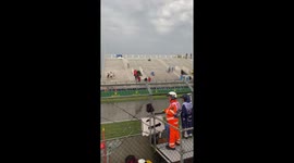 Ferrari race cars racing through giant puddles clear away the spectators with almighty splashes at Montreal Grand Prix eace track