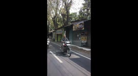 Motorbike Rider Balances Water Bottle on His Head