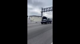 Car Drives Down Interstate With Hood Popped Open