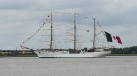 Mexican Navy tall ship ARM Cuauhtémoc sailing the River Thames and proudly flying a gigantic Mexican flag from her stern.