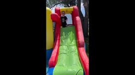 Boy Faceplants Down Inflatable Slide