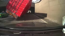 Car narrowly escapes being crushed as oversized truck almost topples over in China