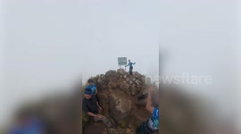 Biblical scenes! Hikers cheer as clouds suddenly part when they reach top of mountain