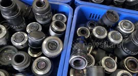 Bargain hunters browse through hundreds of vintage cameras at second-hand shop in Thailand