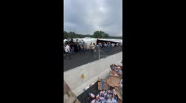 Crowd Removes Merchandise From Wrecked Transport Truck