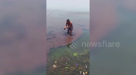 Curious residents wade into lake as volcanic rocks float on the surface in the Philippines