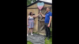 Parents-to-be glowing with happiness while doing a cute gender reveal of their twins