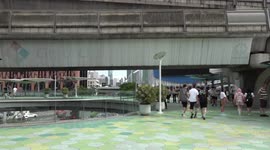 Tourists pose in front of monorail bridge emblazoned with Bangkok amid hopes of economic revival