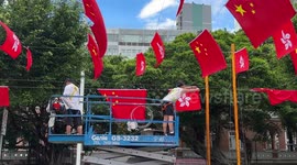 Workers hanging the Chinese national and Hong Kong flags ahead of Hong Kong 26th handover anniversary