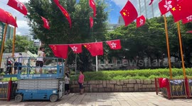 Workers hanging the Chinese national and Hong Kong flags ahead of Hong Kong 26th handover anniversary