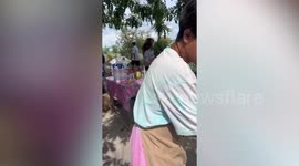 Street vendor serves Americano coffee in green coconut husks