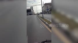 Russian tourist sleeps while sitting on motorcycle stopped mid-traffic in Thailand