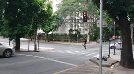 Brazilian street performer juggling on a slackline while cars wait at the lights.