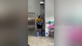 Bungling office worker drops water dispenser jug in amusing workplace fail