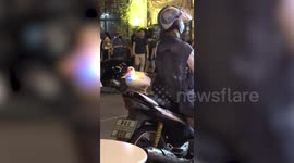 Pet duck wears blinking light necklace and rides pillion on motorcycle with owner