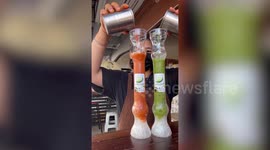 Barista pours ice-cold juice topped with whipped cream in quirky science lab glasses