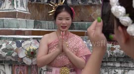 Tourists dress in traditional costume at iconic Buddhist temple in Bangkok