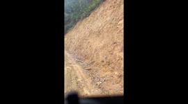 The driver moves the truck through the narrow and winding road between the mountainside