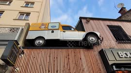 Encrusted car in a building on the roof of the bakery Maison Caquelin, Paris suburb, Villejuif, France.  2 july 2023.