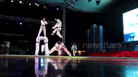 Masters of the martial art of taekwondo demonstrate their skills, techniques and holds on stage. Athletes break the boards with a jump shot. The city of Chungju, South Korea.