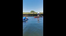 Best Friend pushes man's paddle board to throw him off of it *Harmless Prank*