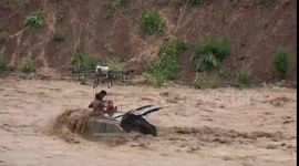 Firefighters rescue stranded motorists on roof of submerged car in raging floodwater
