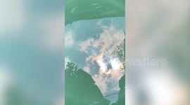 Clever eclipse-watcher observes phenomenon through sun's reflection in water basin