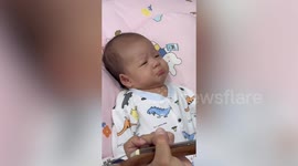 Baby girl grimaces when out-of-tune father plays guitar to her