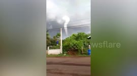 Curved landspout tornado touches down near village during storm in Thailand