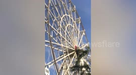 Ferris wheel gondolas spin round during windy weather in the Philippines