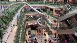 Shoppers ride giant slide in Shanghai shopping mall