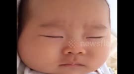 Complicated expressions on a sleeping baby's face