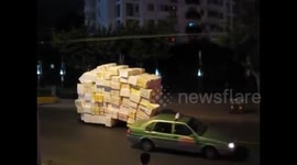 Overloaded tricycle carries two-storey high styrofoam boxes on road