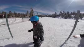 Three-year-old toddler learns to snowboard