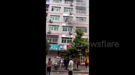 Chinese crowd hold bedsheet to catch baby thrown out of burning flat by mother