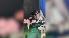 Teenager bangs face and cracks desk chair while teasing friend inside classroom