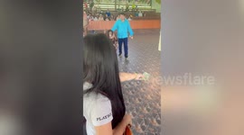 Friendly orangutan stops bicycle to hug pretty tourist at safari show