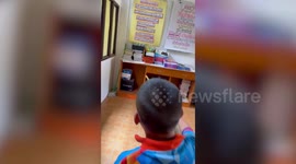 Schoolboys try to catch snake with brooms... then flee when it slithers towards them