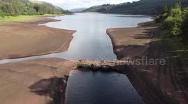 Shrinking water levels after warm weather at South Wales reservoir, UK