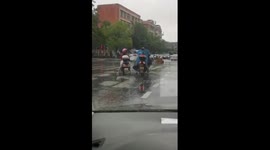 Motorcyclist offers raincoat to unsheltered mum and daughter on rainy day in China