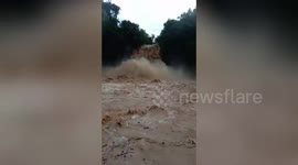 Raging flood cascades like waterfall next to village in the Philippines