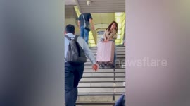 Wholesome moment Japanese commuter helps tourist carry suitcase down stairs