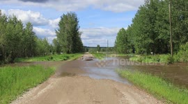 Gravel road being washed out by flooded creek
